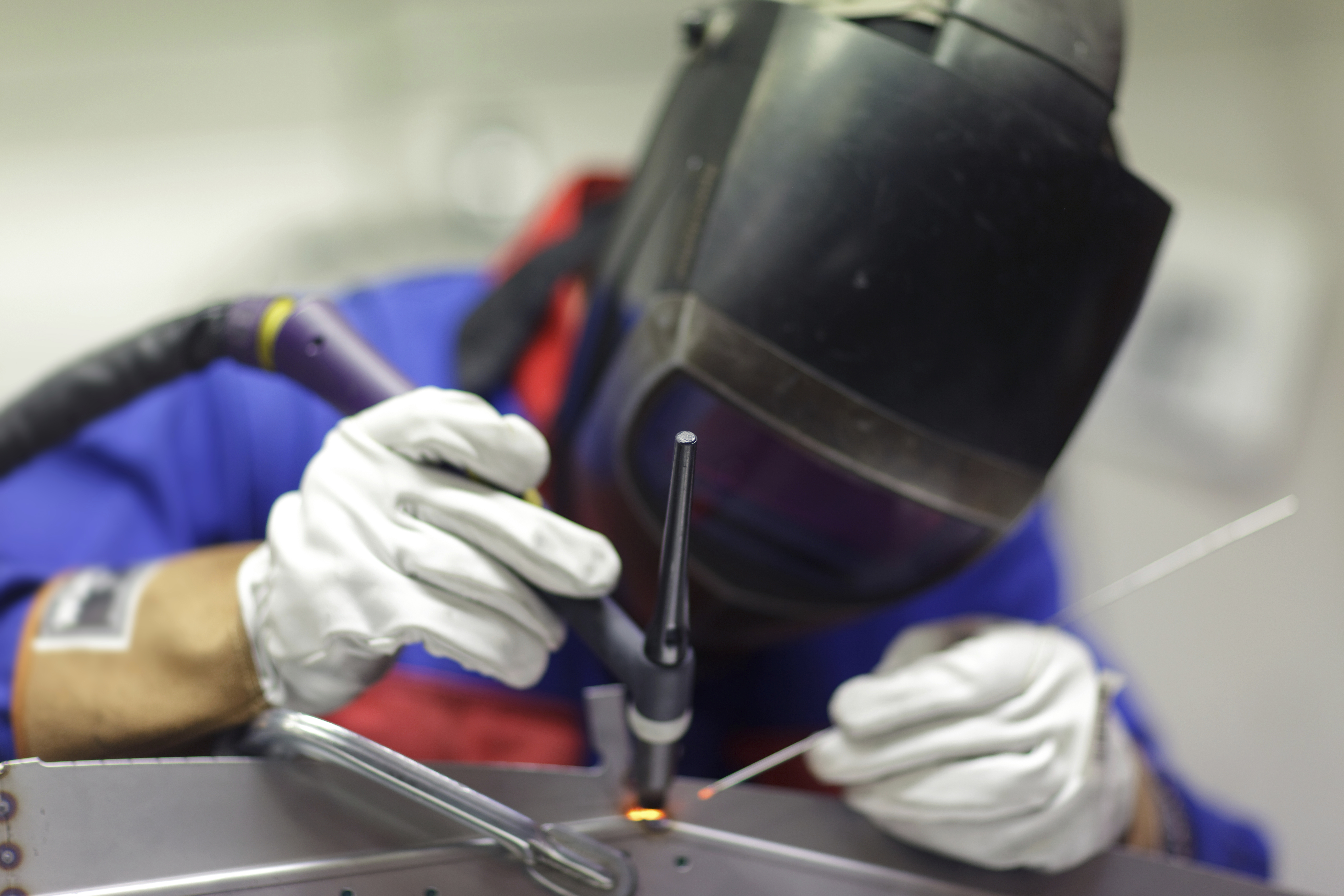 Svejsning af en stålforbindelse udført af en svejser iført beskyttelsesudstyr