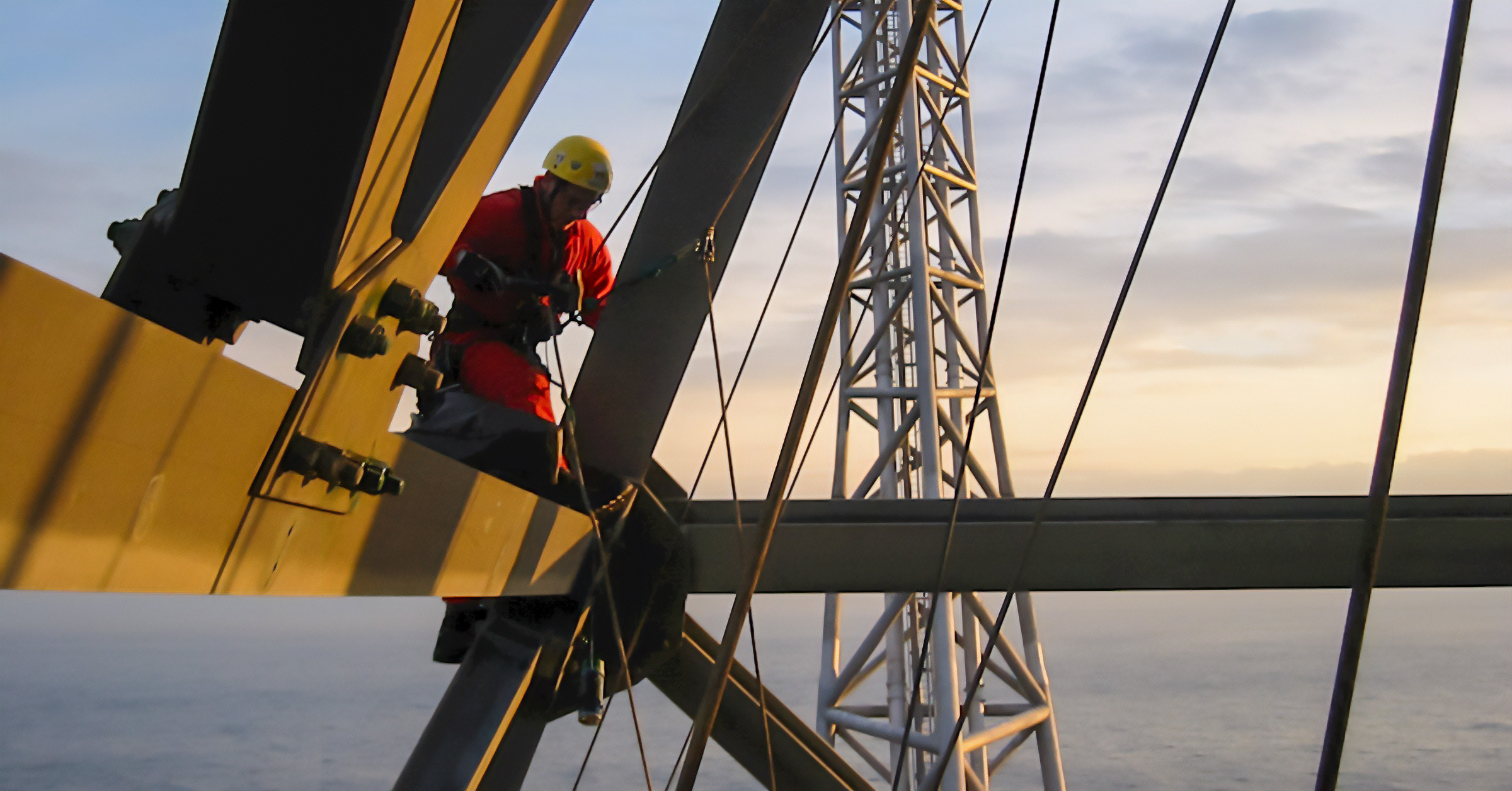 Independent inspector performing inspection work on welded steel connections in a large steel structure at height, verifying weld quality and structural integrity.