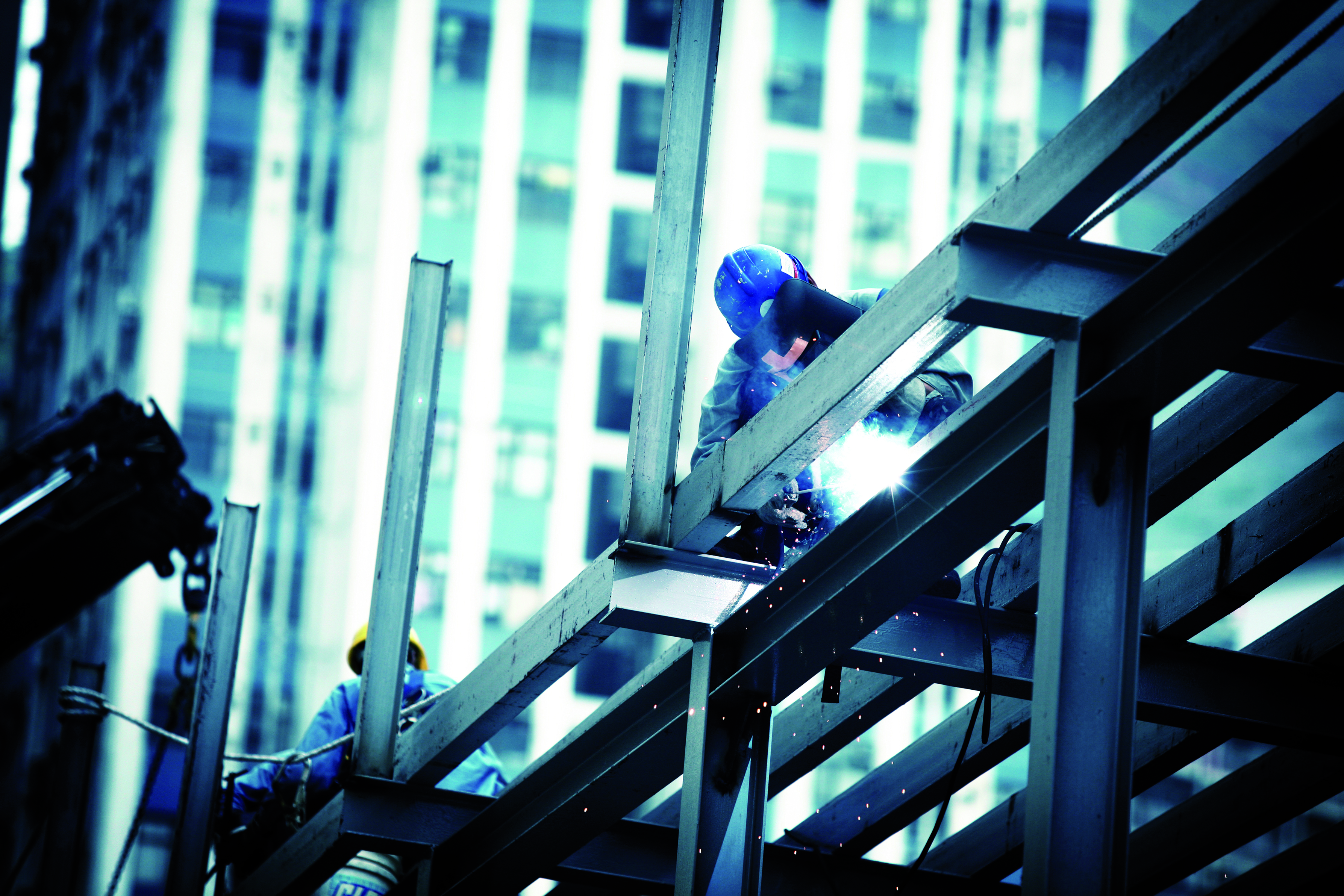 En svejser der arbejder på svejsesamlinger i bærende stålbjælker