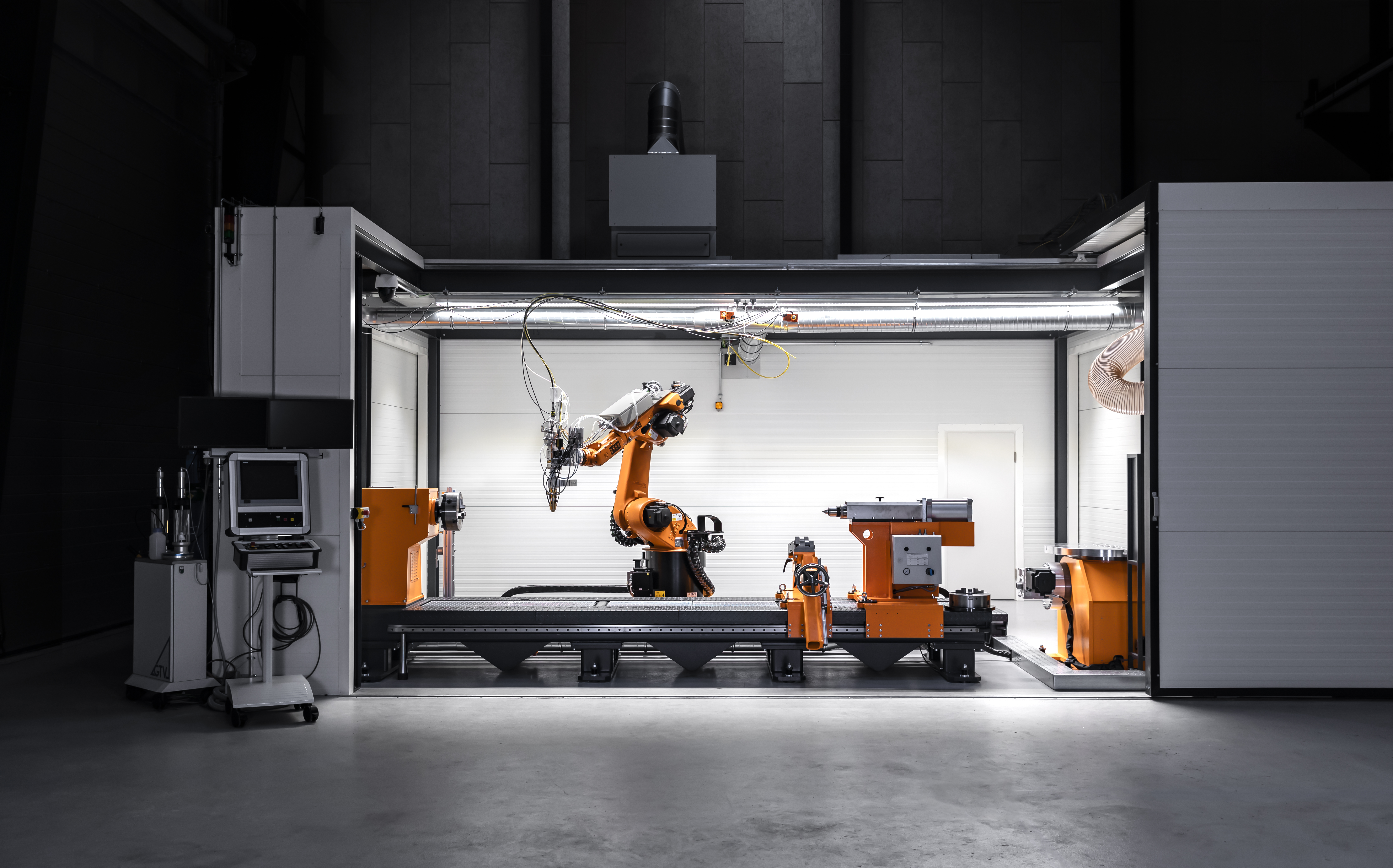 Lasersvejsecelle med industrirobot, CNC-styret håndteringsudstyr og lukket arbejdsområde til lasersvejsning.