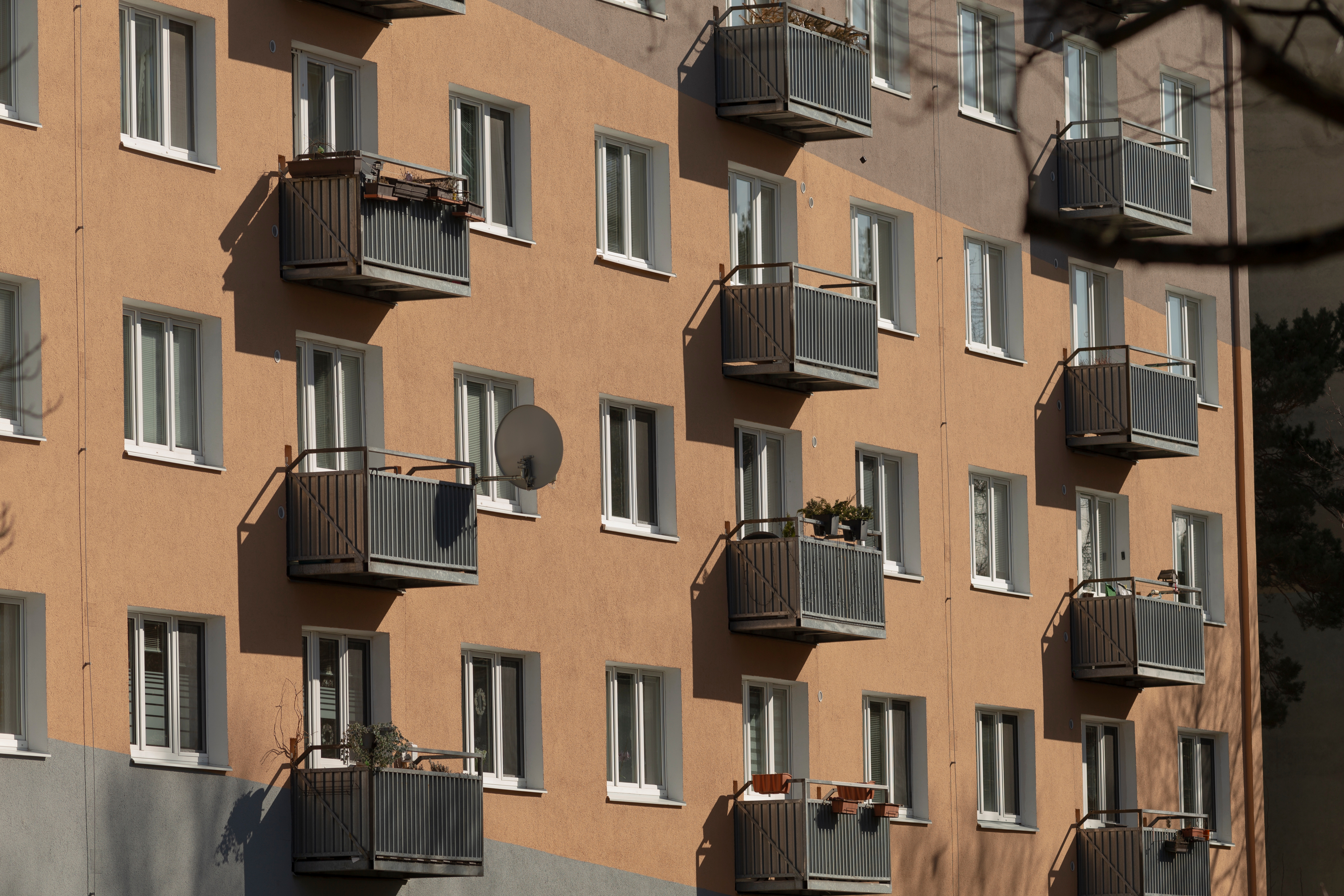 Facade på et boligbyggeri med flere altaner og vinduer.