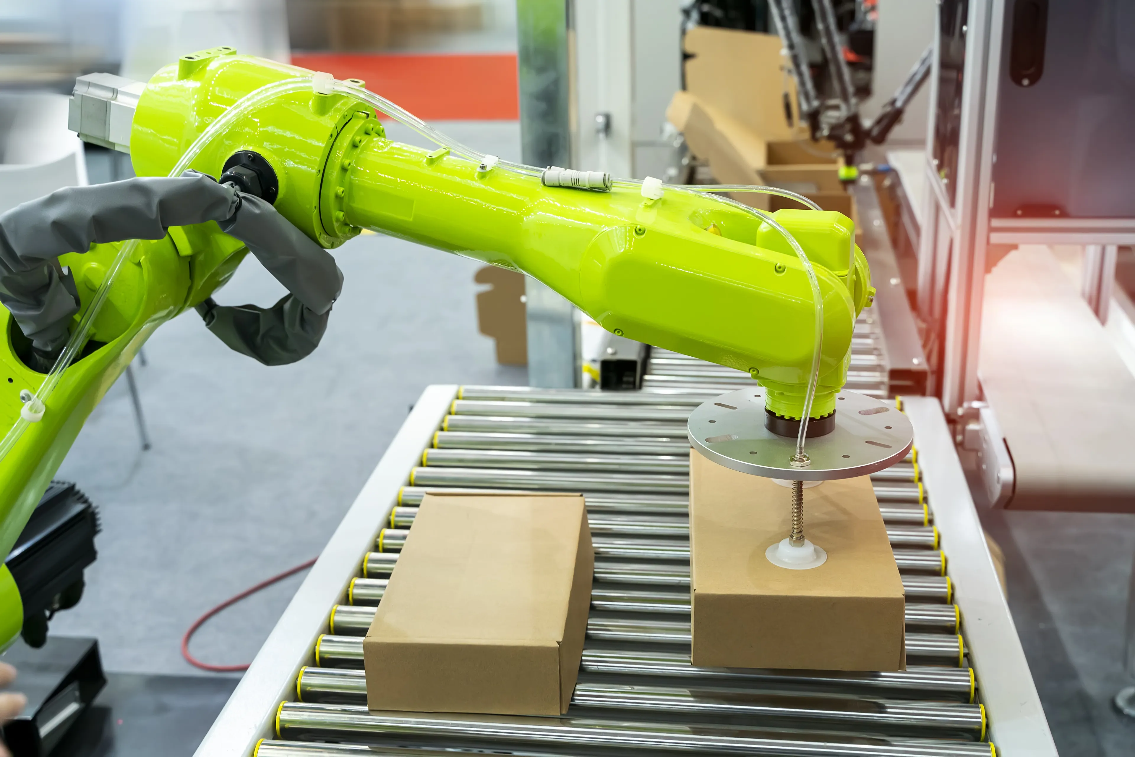 Articulated robotic arm at packaging line in factory